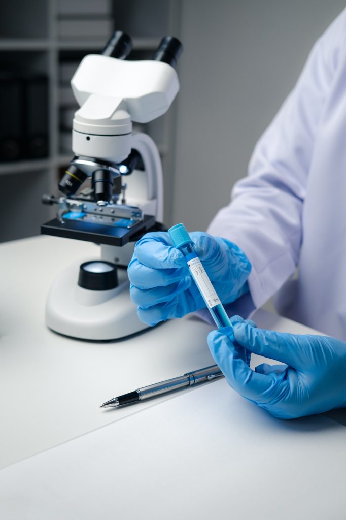 Close up view of scientist analyzing a liquid in the test tubes in laboratory.