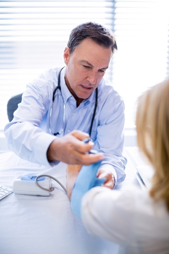 Doctor checking blood pressure of a patient