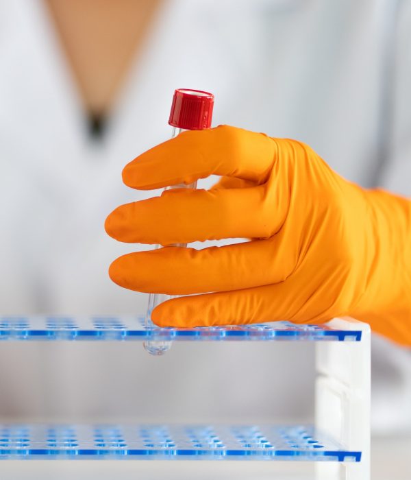 Scientist putting test tube into rack